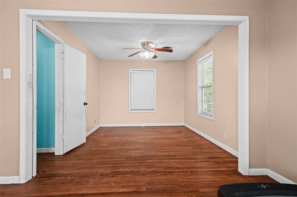 3401 E University Drive, McKinney, TX 75069 Room featuring wood-finish flooring, a ceiling fan with integrated lighting, and dual windows