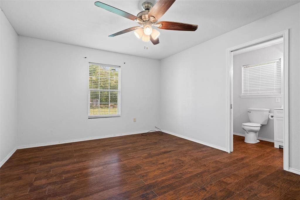 3401 E University Drive, McKinney, TX 75069 Wood-finish flooring, multi-blade ceiling fan with integrated lighting, and single-hung window with horizontal blinds