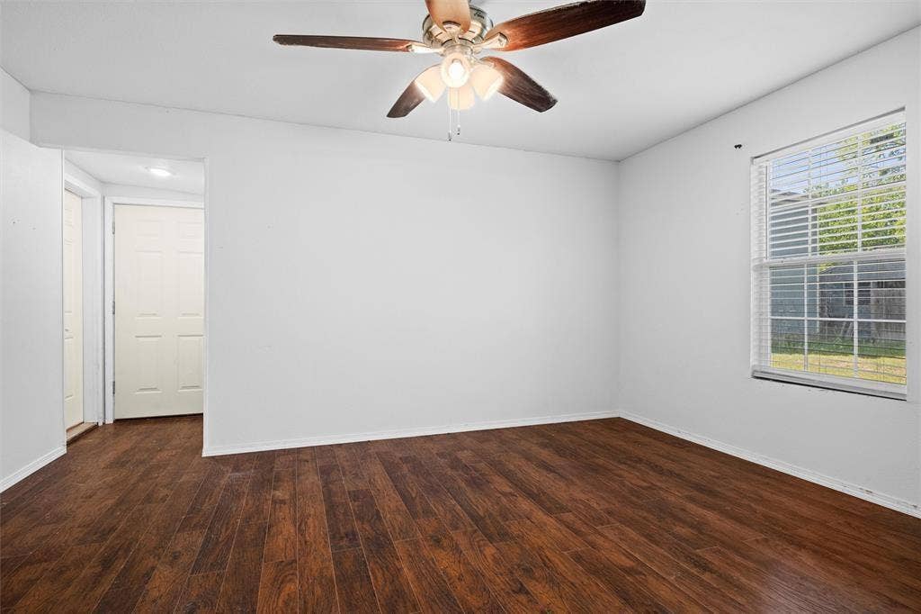 3401 E University Drive, McKinney, TX 75069 Room featuring wood-finish flooring, a multi-pane window with blinds, and a ceiling fan with integrated lighting