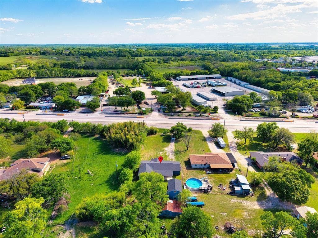 3401 E University Drive, McKinney, TX 75069 Aerial perspective of a property featuring expansive green space, mature trees, a detached secondary structure, and a circular above-ground pool