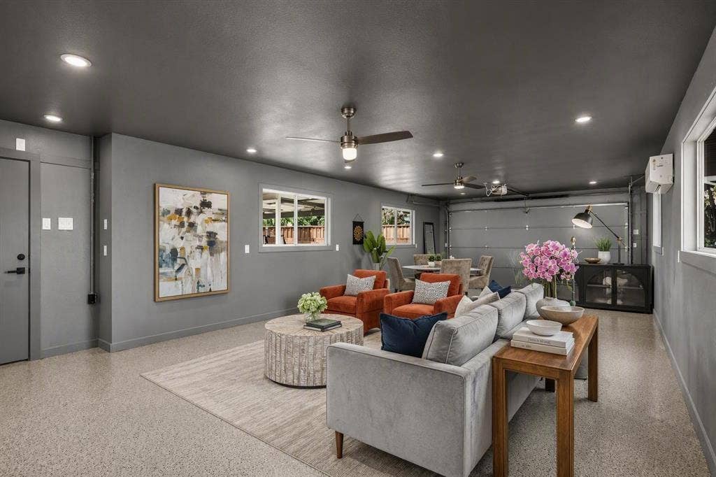 Spacious interior featuring recessed lighting, multiple ceiling fans, neutral-toned walls, and durable epoxy-coated flooring