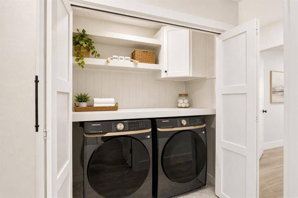 Laundry area featuring white shaker-style bi-fold doors, beadboard backsplash, built-in shelving, an upper cabinet, and a solid-surface countertop