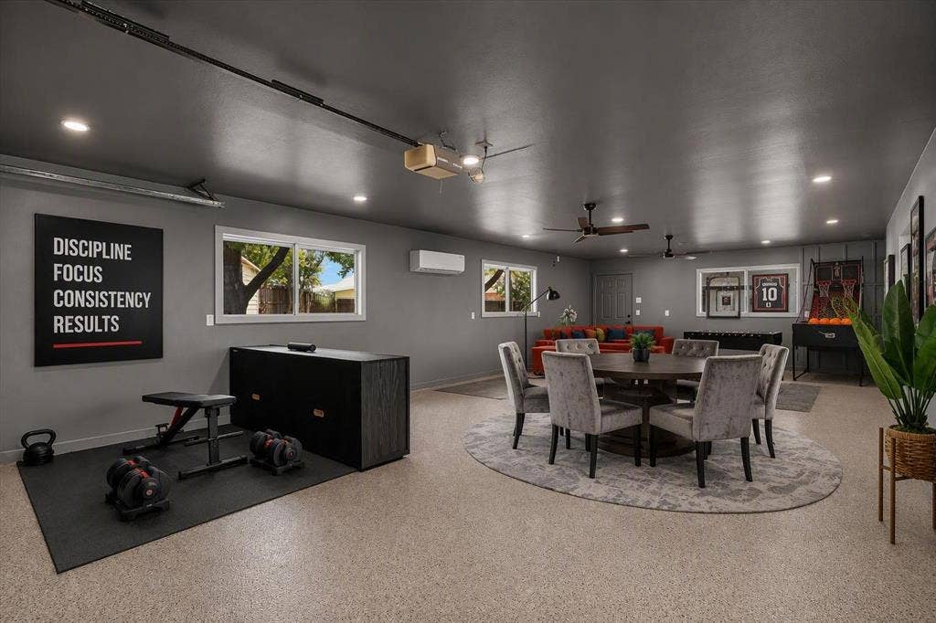 Finished interior space featuring speckled epoxy flooring, recessed lighting, dual ceiling fans, and a wall-mounted ductless climate control unit