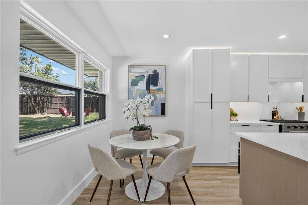 Kitchen featuring flat-panel white cabinetry, wood-finish flooring, quartz countertops, recessed lighting, and large windows
