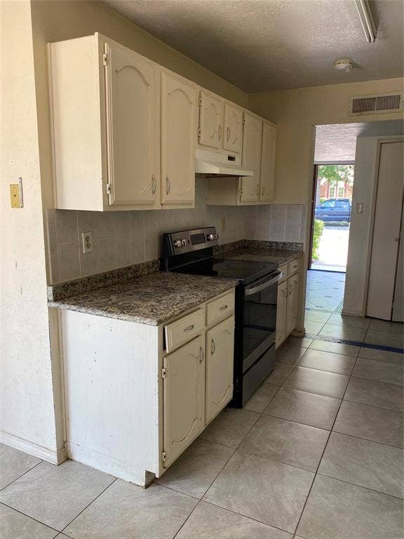 902 Maydelle Lane, Garland, TX 75042 Kitchen featuring painted cabinetry, stone-finish countertops, tiled backsplash, and ceramic tile flooring