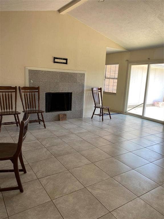 902 Maydelle Lane, Garland, TX 75042 Vaulted ceiling, stone-surround fireplace, large-format tile flooring, and sliding glass doors