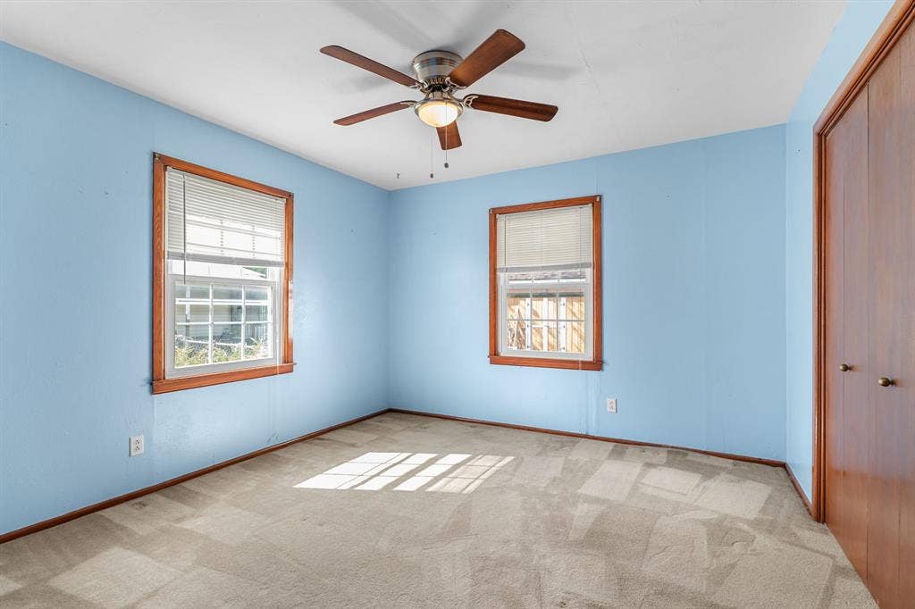 920 Avenue C, Lacy Lakeview, TX 76705 Interior space featuring wall-to-wall carpeting, dual windows with wood-trim finish, a ceiling-mounted light fixture with fan, and wood-finish closet doors