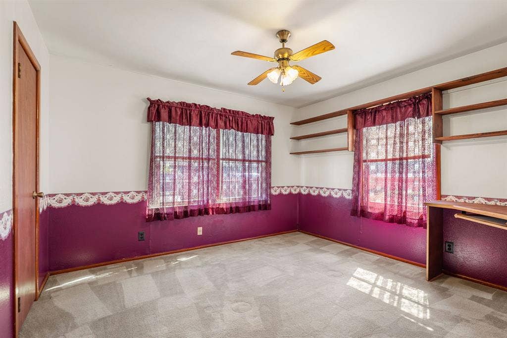 920 Avenue C, Lacy Lakeview, TX 76705 Room featuring wall-to-wall carpeting, ceiling fan with integrated lighting, and custom built-in wooden shelving with an attached workspace desk