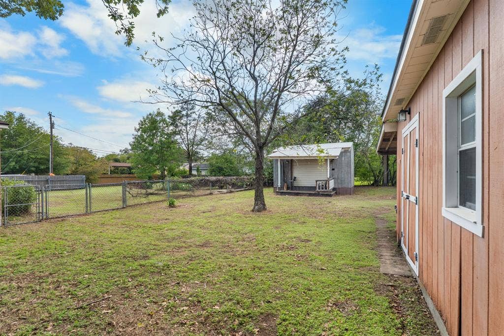 920 Avenue C, Lacy Lakeview, TX 76705 Spacious backyard featuring a chain-link fence, mature trees, and a detached structure