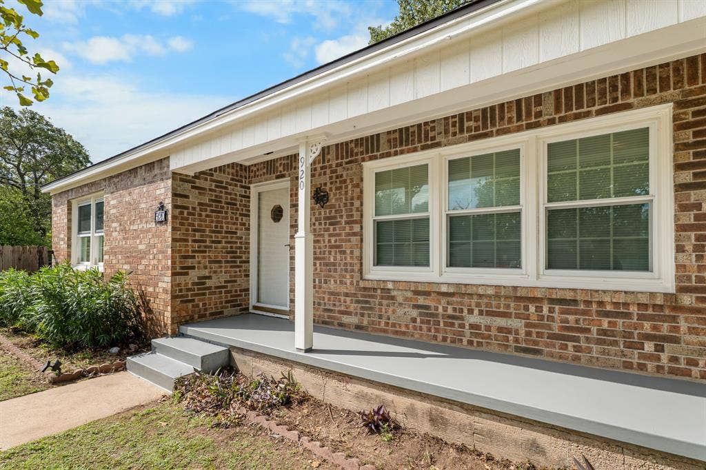920 Avenue C, Lacy Lakeview, TX 76705 Brick exterior featuring a covered front porch, white-trim multi-pane windows, and a decorative support column