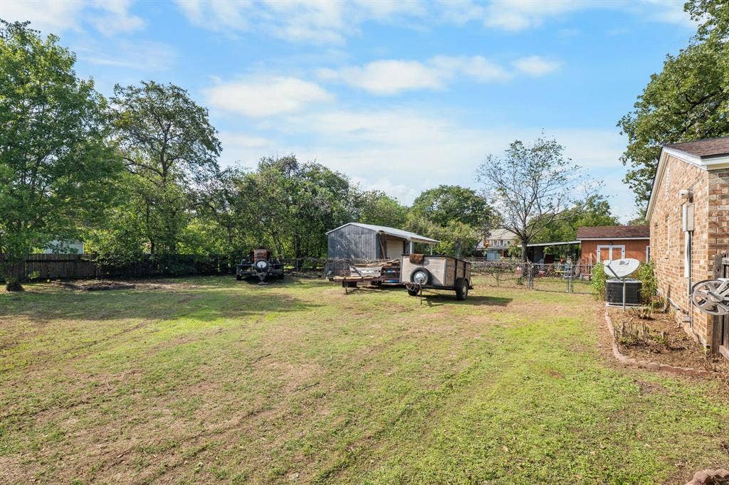 920 Avenue C, Lacy Lakeview, TX 76705 Expansive backyard featuring a brick exterior wall, chain-link fencing, and mature trees