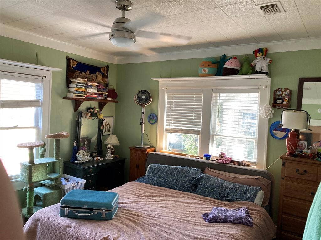 Room featuring a brushed-nickel ceiling fan with integrated lighting, multi-pane windows with horizontal blinds, and built-in wall shelving