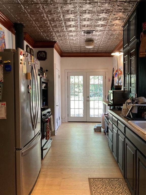Kitchen featuring a decorative pressed-tin ceiling, wood-finish flooring, dark-finish cabinetry, and French-style glass pane doors