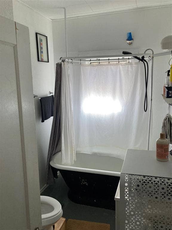 Clawfoot tub featuring a black exterior finish, white interior, and wall-mounted shower hardware