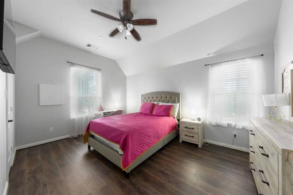 Vaulted ceilings, wood-finish flooring, and a multi-blade ceiling fan with integrated lighting