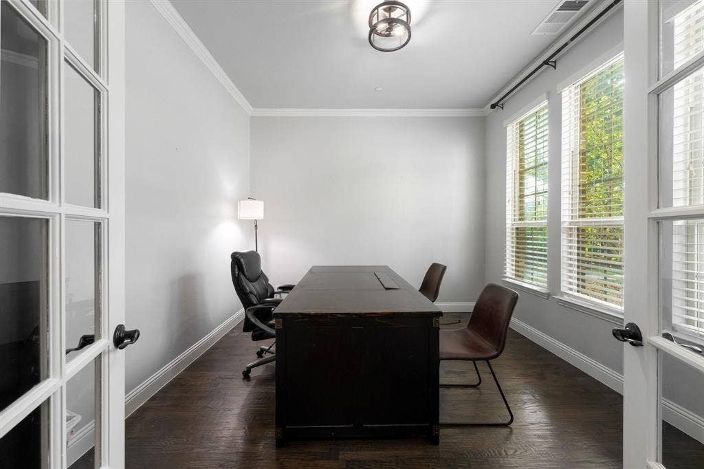 Room featuring French doors, wood-finish flooring, crown molding, and dual windows with blinds