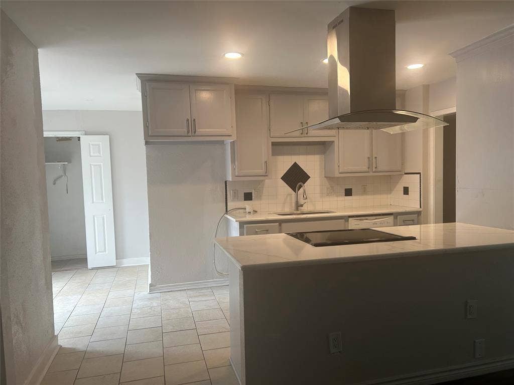 1314 Frio Lane, Garland, TX 75040 Kitchen featuring a quartz countertop island with an integrated cooktop, stainless steel chimney-style range hood, shaker-style cabinetry, square tile backsplash, and ceramic tile flooring
