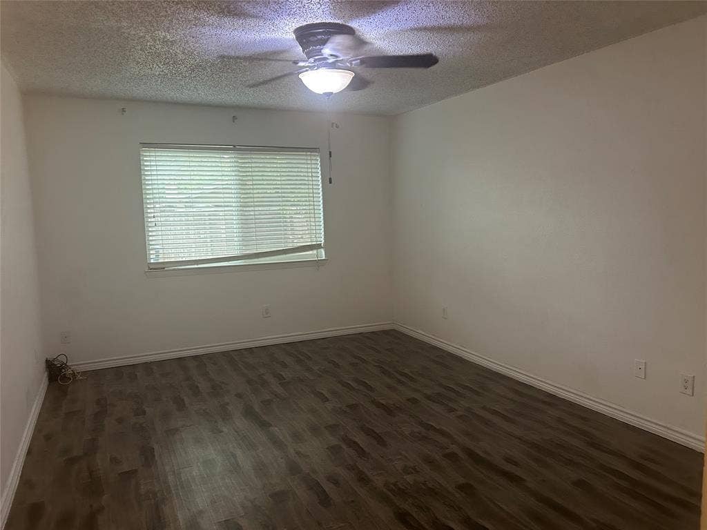 1314 Frio Lane, Garland, TX 75040 Room featuring wood-finish flooring, a ceiling fan with integrated lighting, and a window with horizontal blinds