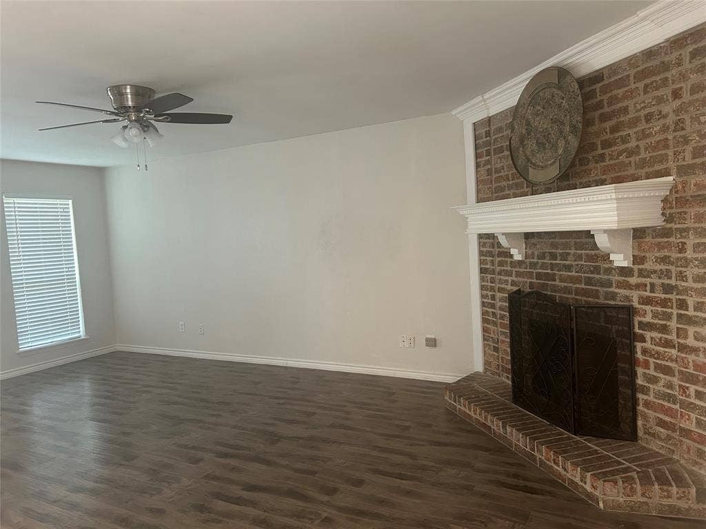 1314 Frio Lane, Garland, TX 75040 Brick fireplace with a crown-molded mantel, wood-finish flooring, and a ceiling fan