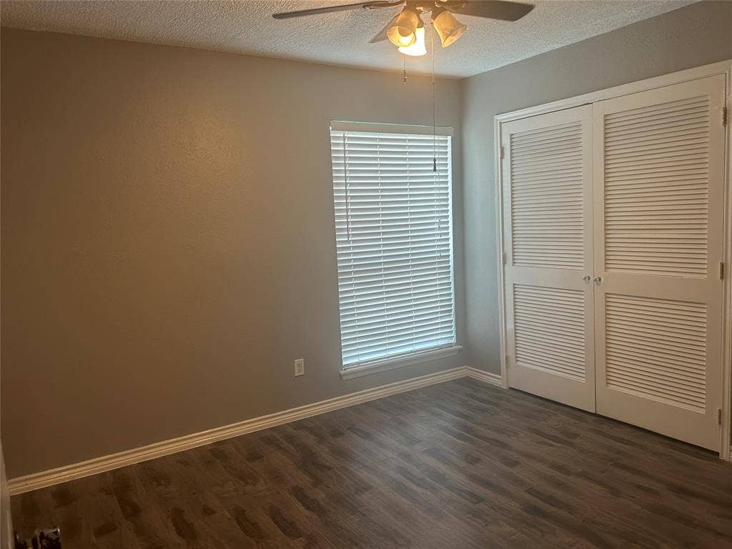 1314 Frio Lane, Garland, TX 75040 Wood-finish flooring, double louvered closet doors, ceiling fan with integrated light fixture, and horizontal window blinds