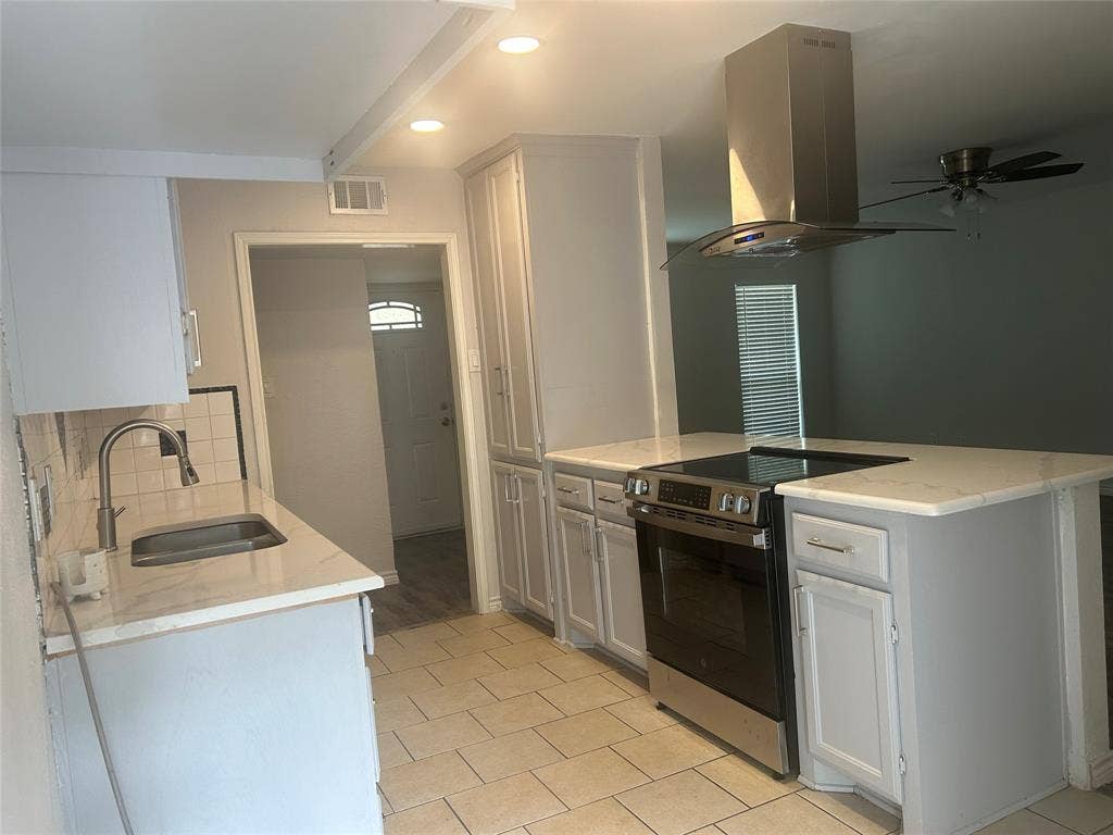 1314 Frio Lane, Garland, TX 75040 Kitchen featuring white cabinetry, stone-finish countertops, stainless steel range with overhead vent hood, undermount sink, and tile flooring