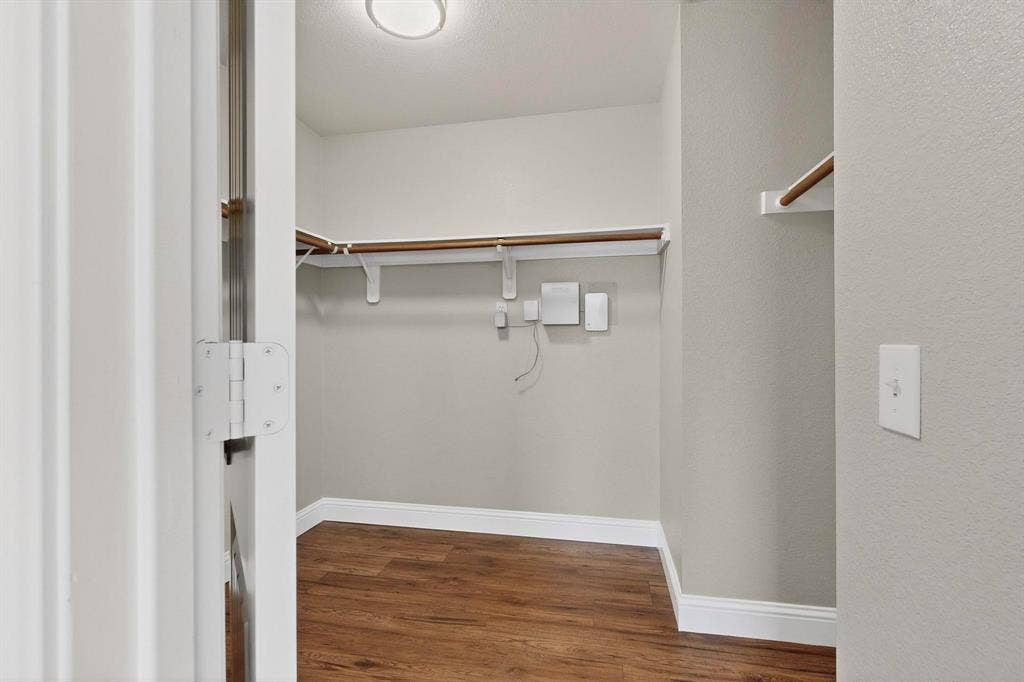 4803 Silver Avenue, Dallas, TX 75223 Walk-in closet featuring wood-finish flooring, white built-in shelving, and a ceiling-mounted light fixture