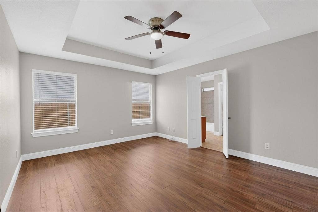 4803 Silver Avenue, Dallas, TX 75223 Tray ceiling with a central fan, wood-finish flooring, and double doors