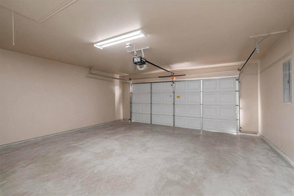 4803 Silver Avenue, Dallas, TX 75223 Finished garage interior featuring smooth-finish walls, a multi-panel sectional door, overhead fluorescent lighting, and a concrete floor