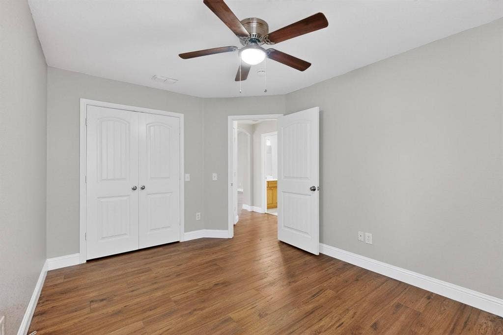 4803 Silver Avenue, Dallas, TX 75223 Room featuring wood-finish flooring, a central ceiling fan with integrated lighting, and double-panel closet doors