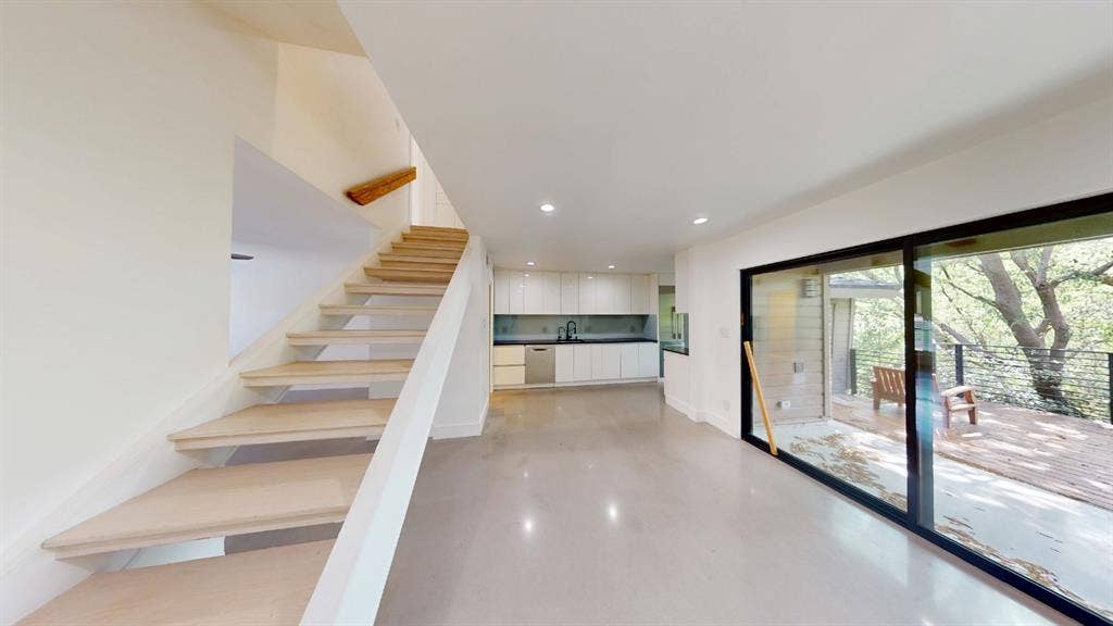 Open floor plan featuring a staircase with wood treads, flat-panel cabinetry, recessed lighting, and large sliding glass doors