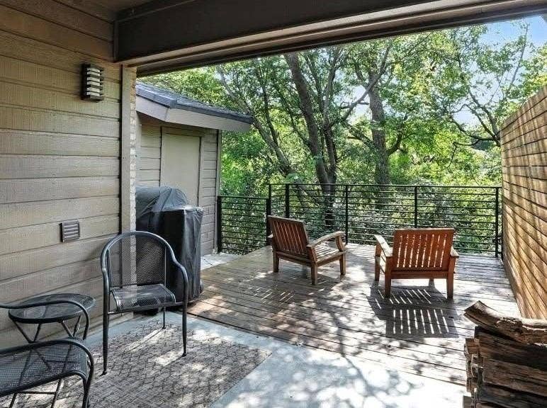Covered deck featuring wood-finish decking, horizontal slat privacy fencing, and black metal railing