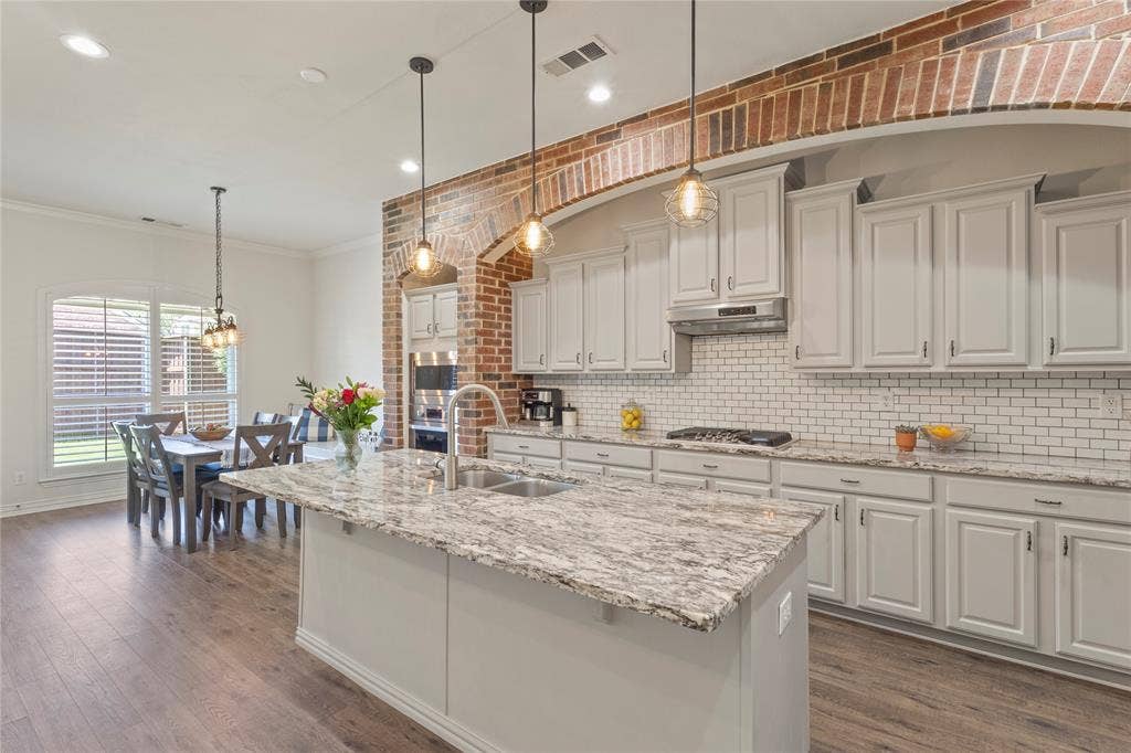 Brick accent wall, neutral granite countertop, open