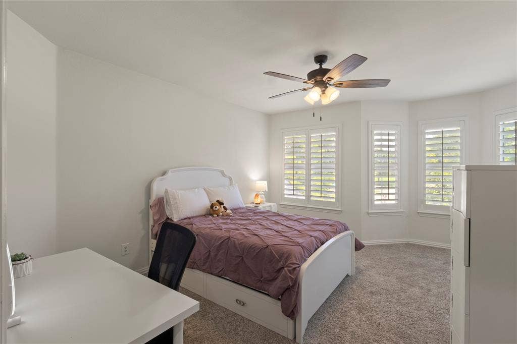 Upstairs bedroom with rounded wall and plantation shutters