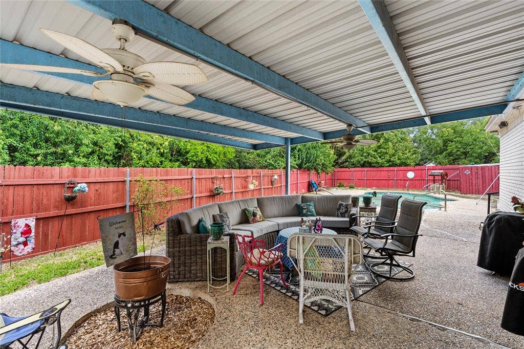 Covered patio featuring an expansive concrete surface, integrated ceiling fans, and a private swimming pool