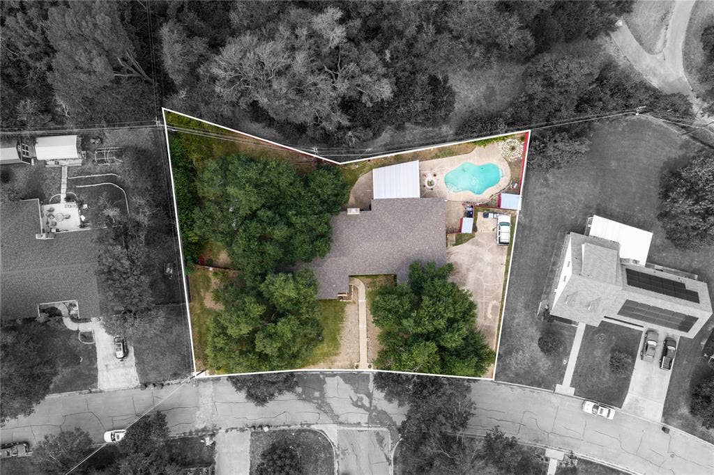 Aerial perspective featuring an expansive lot with mature trees, an in-ground swimming pool, a concrete patio, and a dedicated walkway