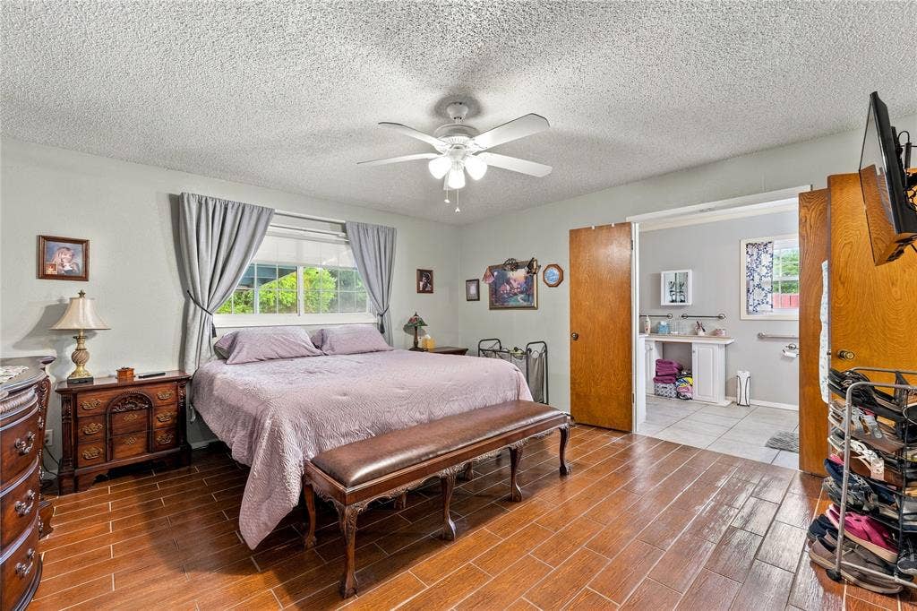 Wood-finish tile flooring, ceiling fan with integrated lighting, dual-pane window, and interior wood-panel doors