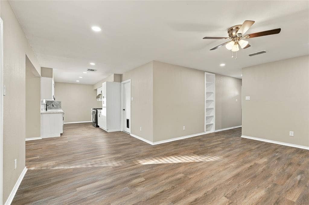 Wood-finish flooring, recessed lighting, built-in shelving, and a ceiling fan with integrated light fixtures