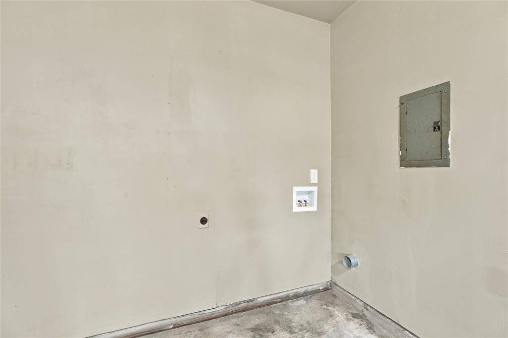 Utility space featuring wall-mounted laundry hookups, dedicated electrical panel access, and an exterior ventilation port