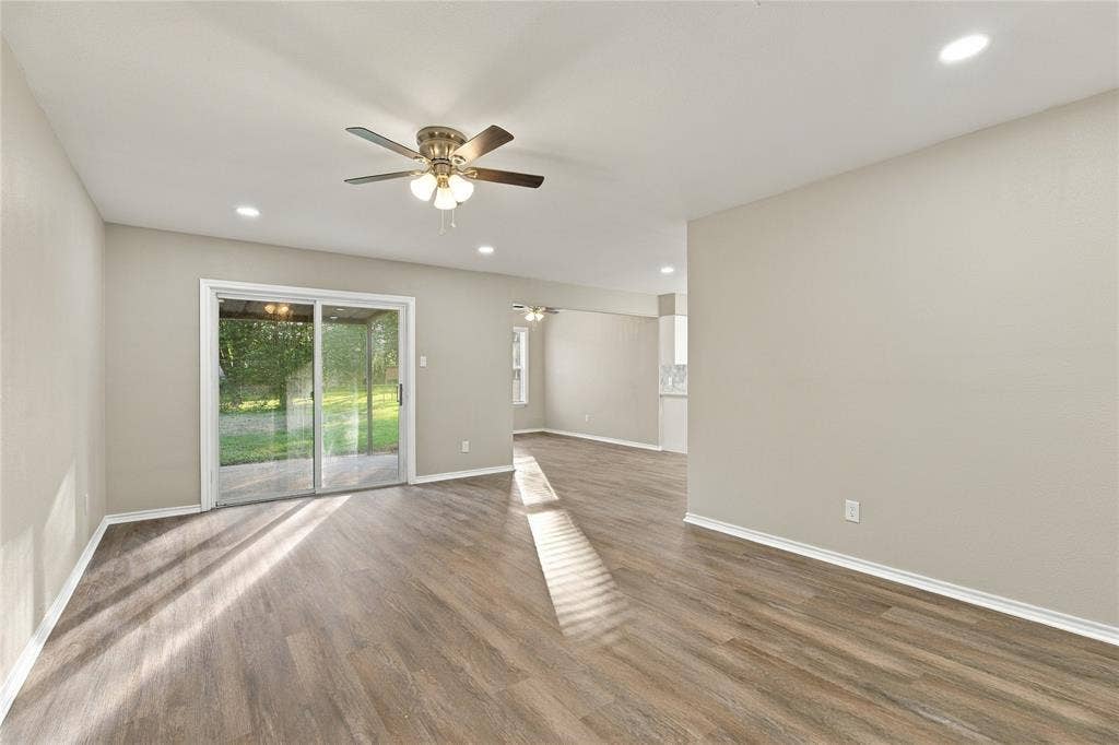 Interior space featuring wood-finish flooring, recessed lighting, a ceiling fan with integrated light fixture, and sliding glass doors
