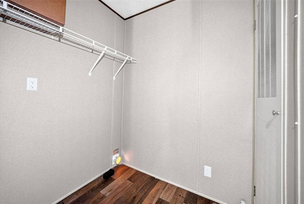 222 W Acres Road, Gun Barrel City, TX 75156 Storage space featuring wood-finish flooring, a white wire shelving system, and a louvered door