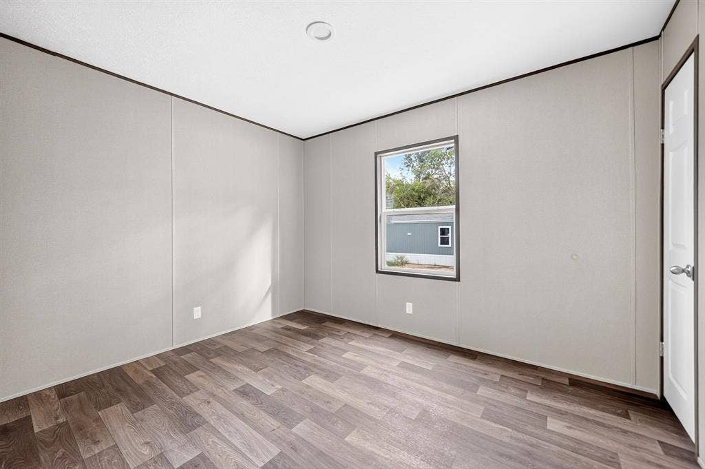 222 W Acres Road, Gun Barrel City, TX 75156 Neutral-toned wall panels, wood-finish flooring, recessed ceiling lighting, a single-hung window with dark trim, and a paneled interior door