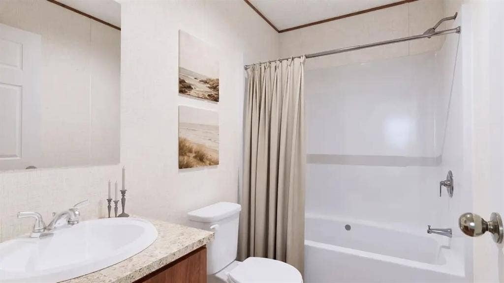 222 W Acres Road, Gun Barrel City, TX 75156 Bathroom featuring a vanity with a stone-finish countertop, an oval drop-in sink, a wall-mounted mirror, and a combination tub and shower with a chrome fixture