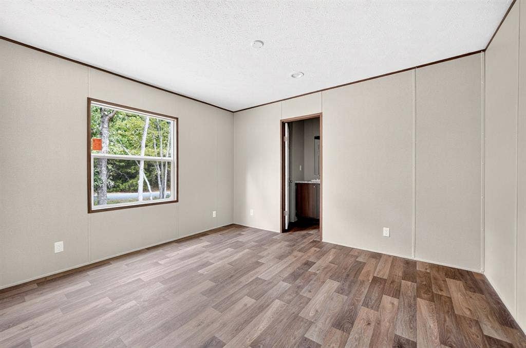 222 W Acres Road, Gun Barrel City, TX 75156 Neutral-toned wall paneling, wood-finish flooring, and a single-pane window with dark trim