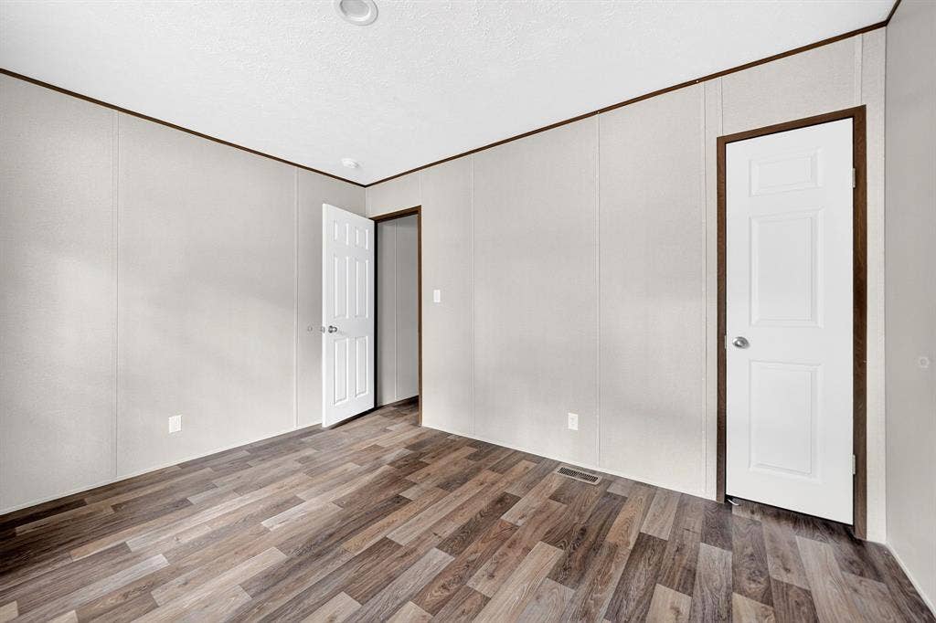 222 W Acres Road, Gun Barrel City, TX 75156 Interior room featuring wood-finish flooring, neutral panel walls, recessed ceiling lighting, and six-panel interior doors with dark wood-tone frames