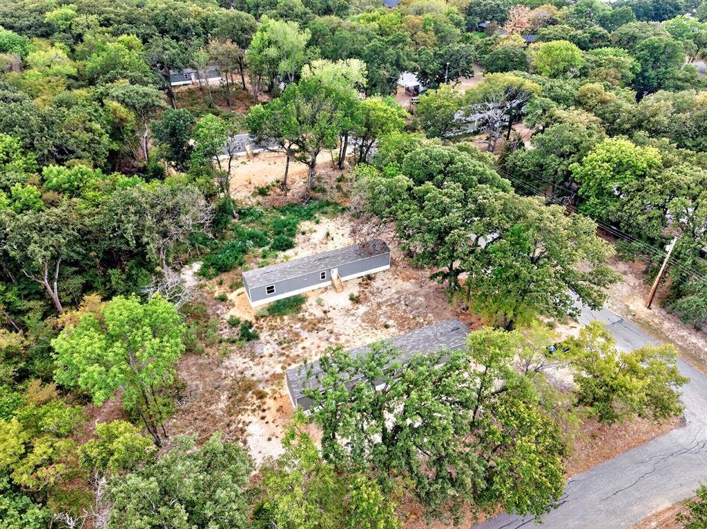 222 W Acres Road, Gun Barrel City, TX 75156 Aerial perspective of a detached residential structure situated on a wooded lot featuring extensive mature tree canopy and paved street access