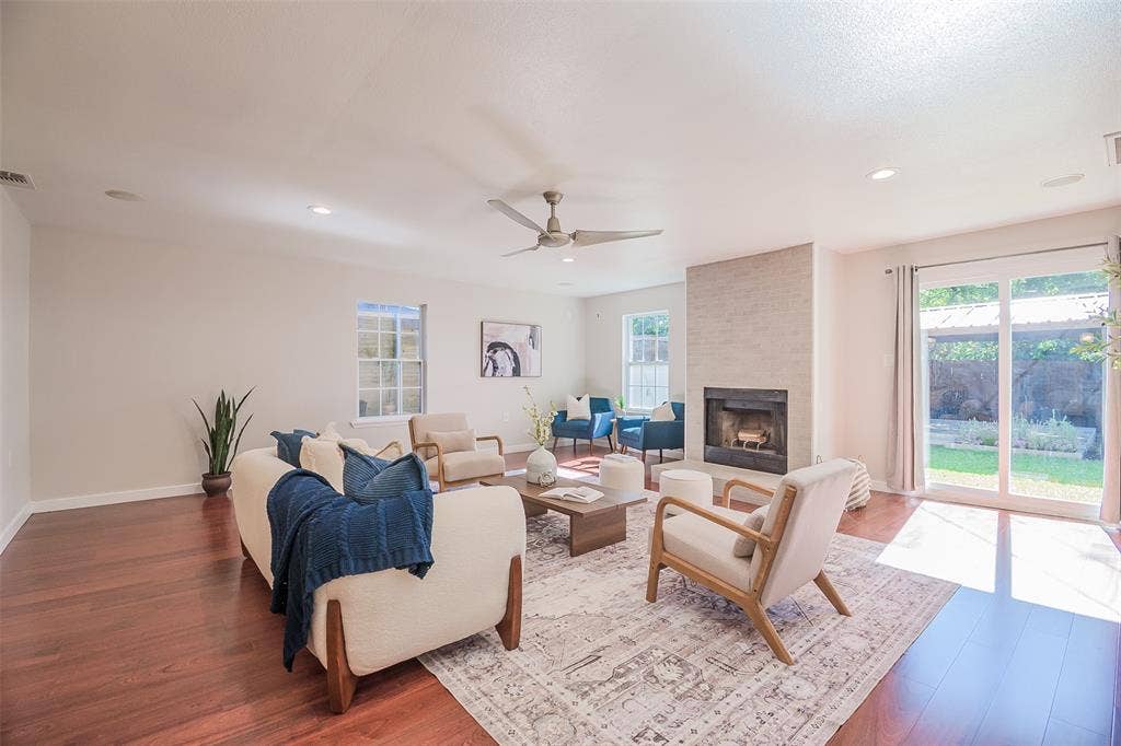 8050 Fall River Drive, Dallas, TX 75228 Living area featuring wood-finish flooring, a floor-to-ceiling fireplace with stone-style surround, recessed lighting, a ceiling fan, and sliding glass doors