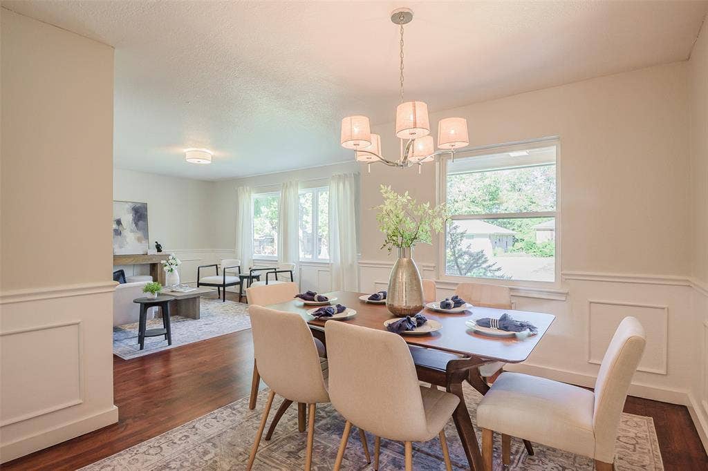 8050 Fall River Drive, Dallas, TX 75228 Dining area featuring wood-finish flooring, white wainscoting, and a multi-arm chandelier