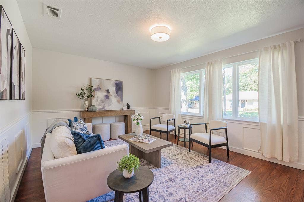 8050 Fall River Drive, Dallas, TX 75228 Living area featuring wood-finish flooring, wainscoting, and multi-pane windows with natural light