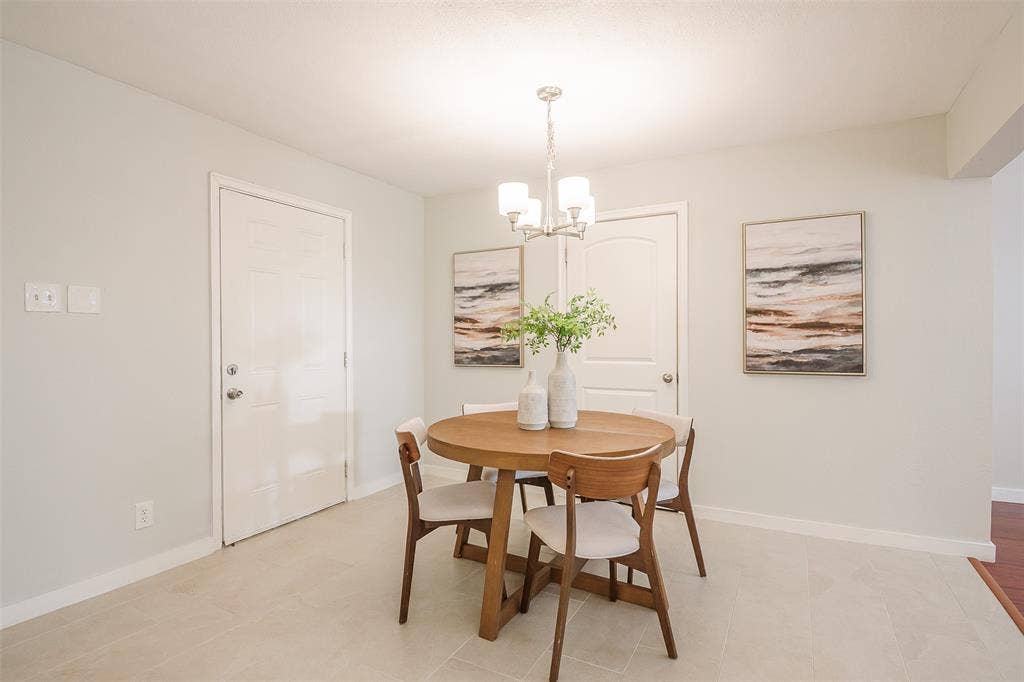 8050 Fall River Drive, Dallas, TX 75228 Neutral-toned tile flooring, four-panel interior doors, and a multi-light metal chandelier