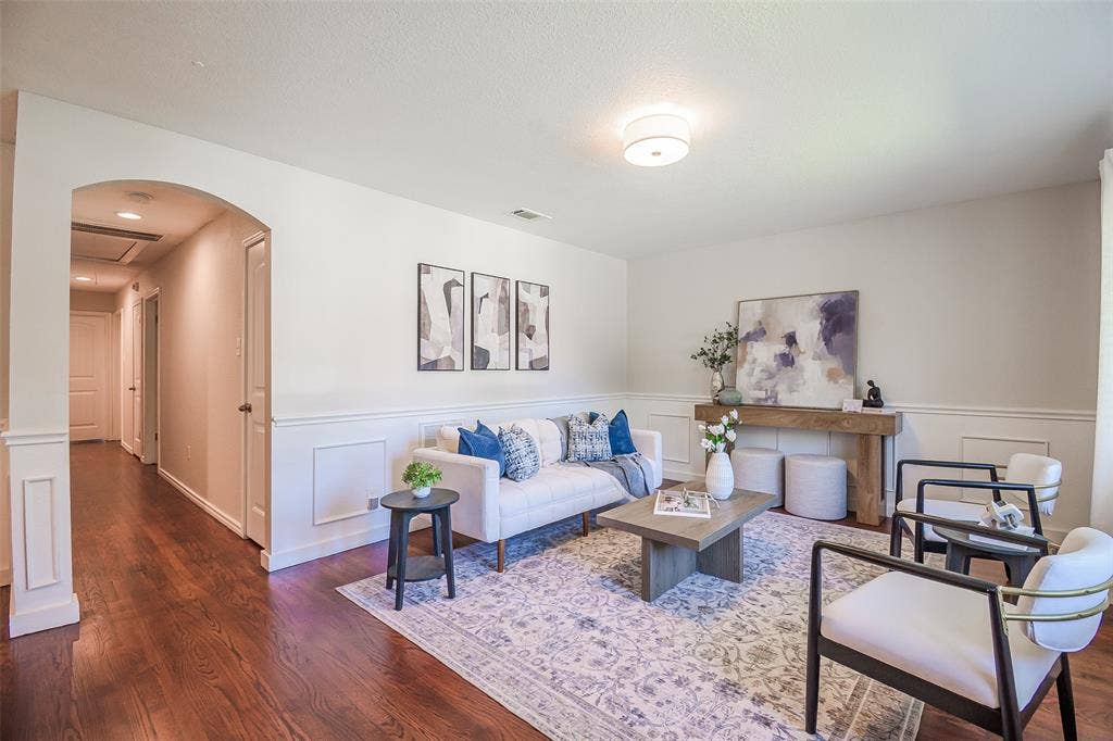8050 Fall River Drive, Dallas, TX 75228 Wood-finish flooring, architectural archway with column detailing, and wainscoting throughout